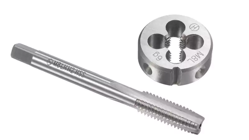 A close-up of a tap tool cutting internal threads into a pre-drilled hole