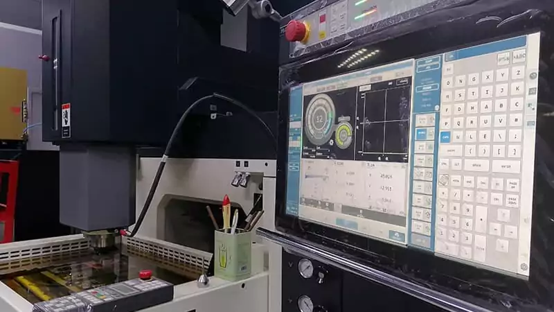 A CNC control panel on an EDM machine, showing the link between the two technologies