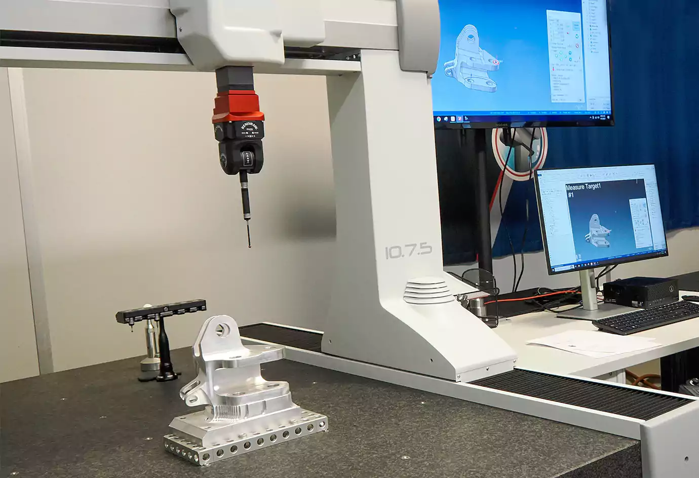 A machinist using a CMM to inspect a part with complex GD&T callouts